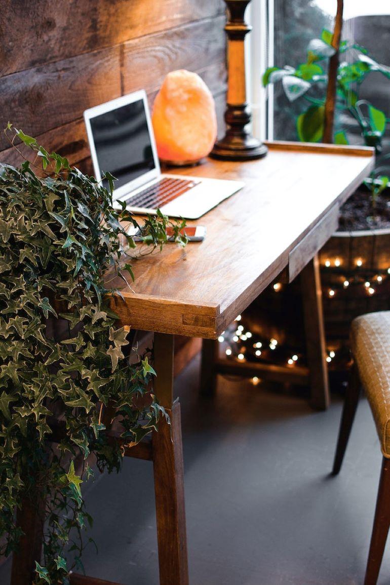 A wooden table with a laptop on it.