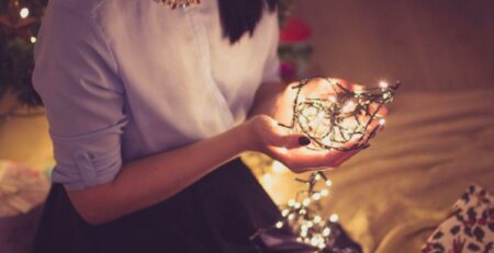 A woman holding Christmas lights