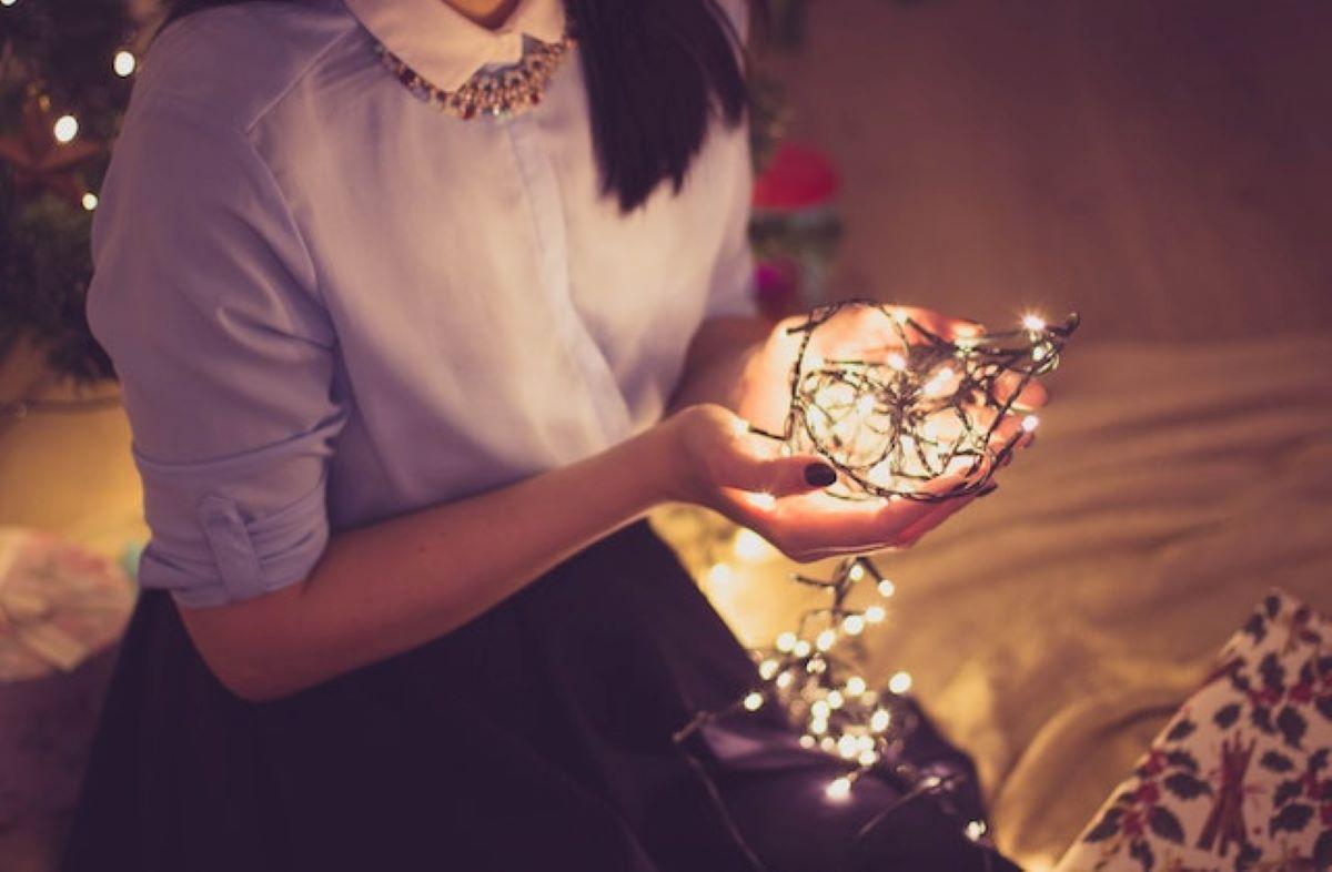 A woman holding Christmas lights