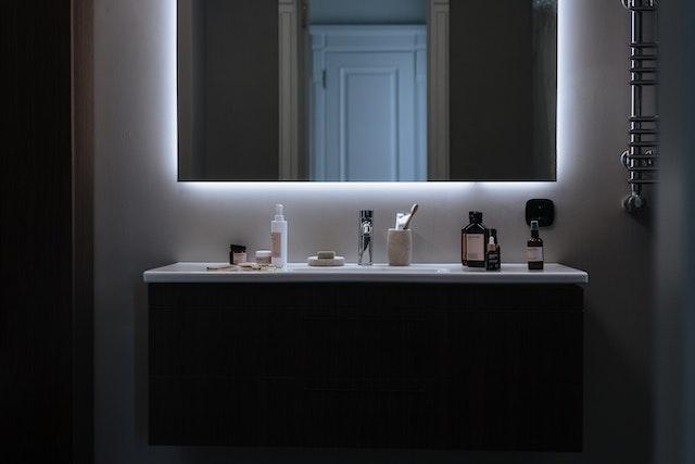 A modern bathroom with an LED mirror.